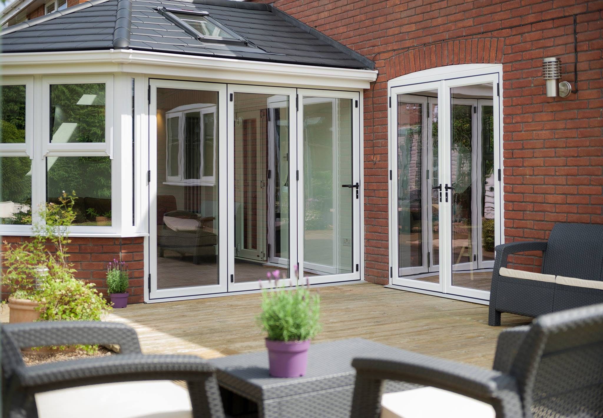 Aluminium bi-fold doors fully opened onto a patio, slim sightlines
