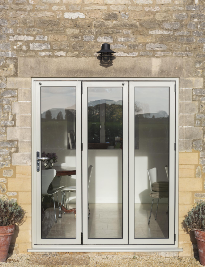 Large bifold door system opening onto garden, offering seamless indoor-outdoor living.