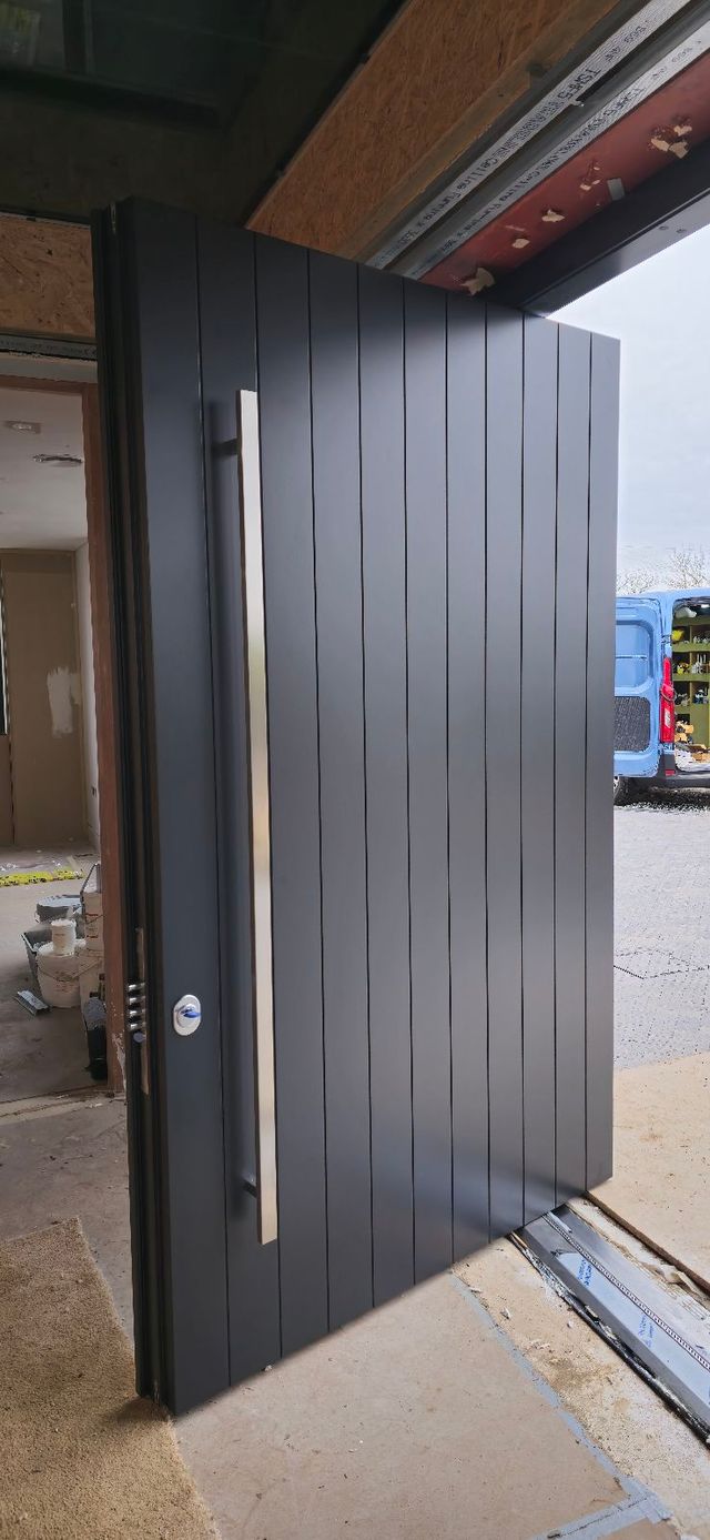 Large pivot high security entrance door with concealed heavy-duty pivot hinge